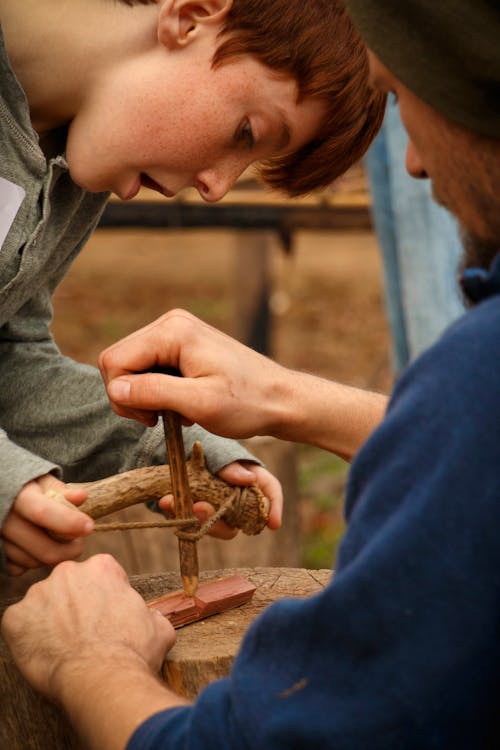 HSMC staff person teaches a young visitor how to start a fire with a bowdrill