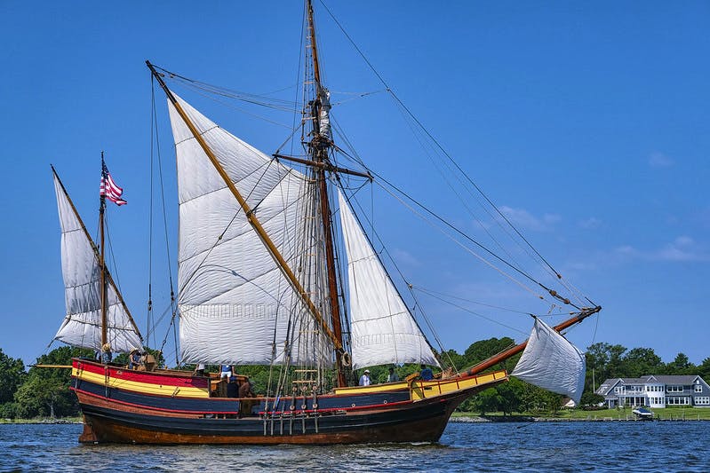 The ship Maryland Dove in the river, with sails unfurled.