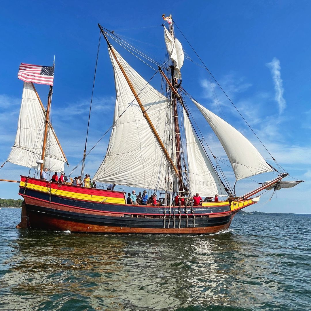 Tall ship Maryland Dove is sailing in the river. The sails are open.