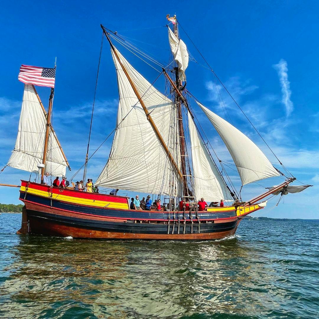 Tall ship Maryland Dove is sailing in the river. The sails are open.