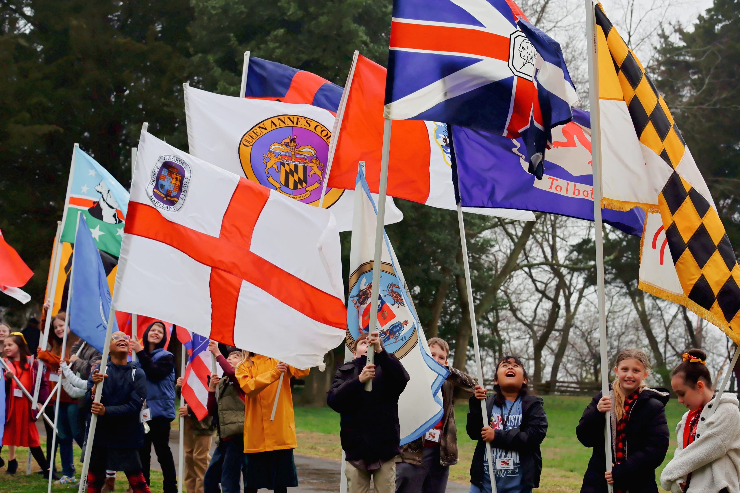 Students lined up holding Maryland county flags