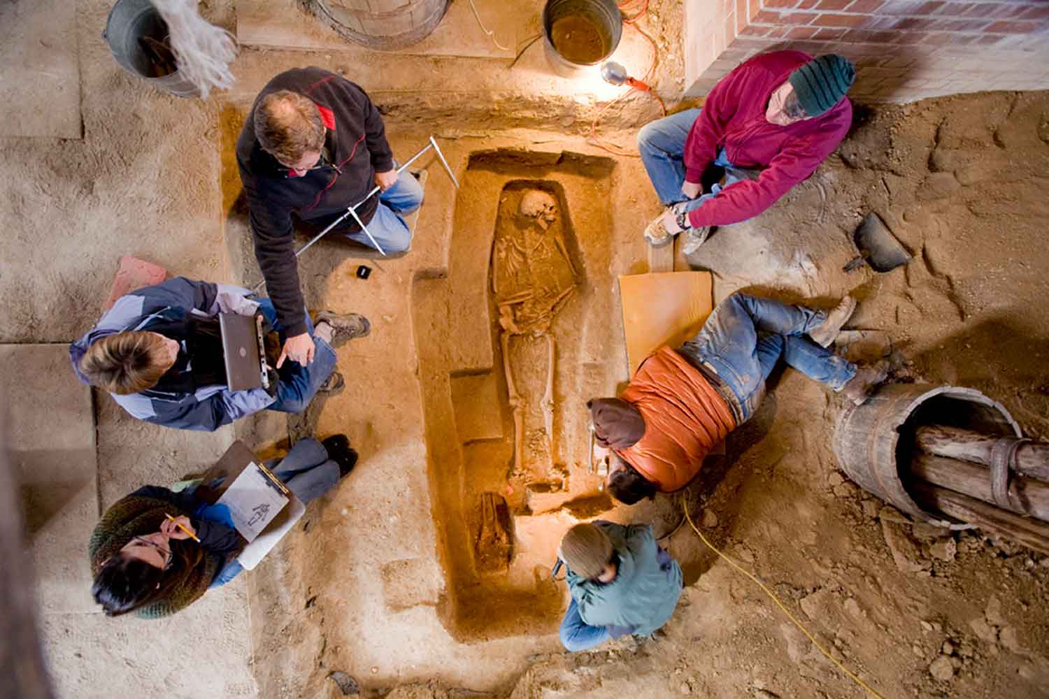 Forensic anthropologists from the Smithsonian Institution work alongside HSMC archaeologists to document and excavate a burial inside the reconstructed Brick Chapel