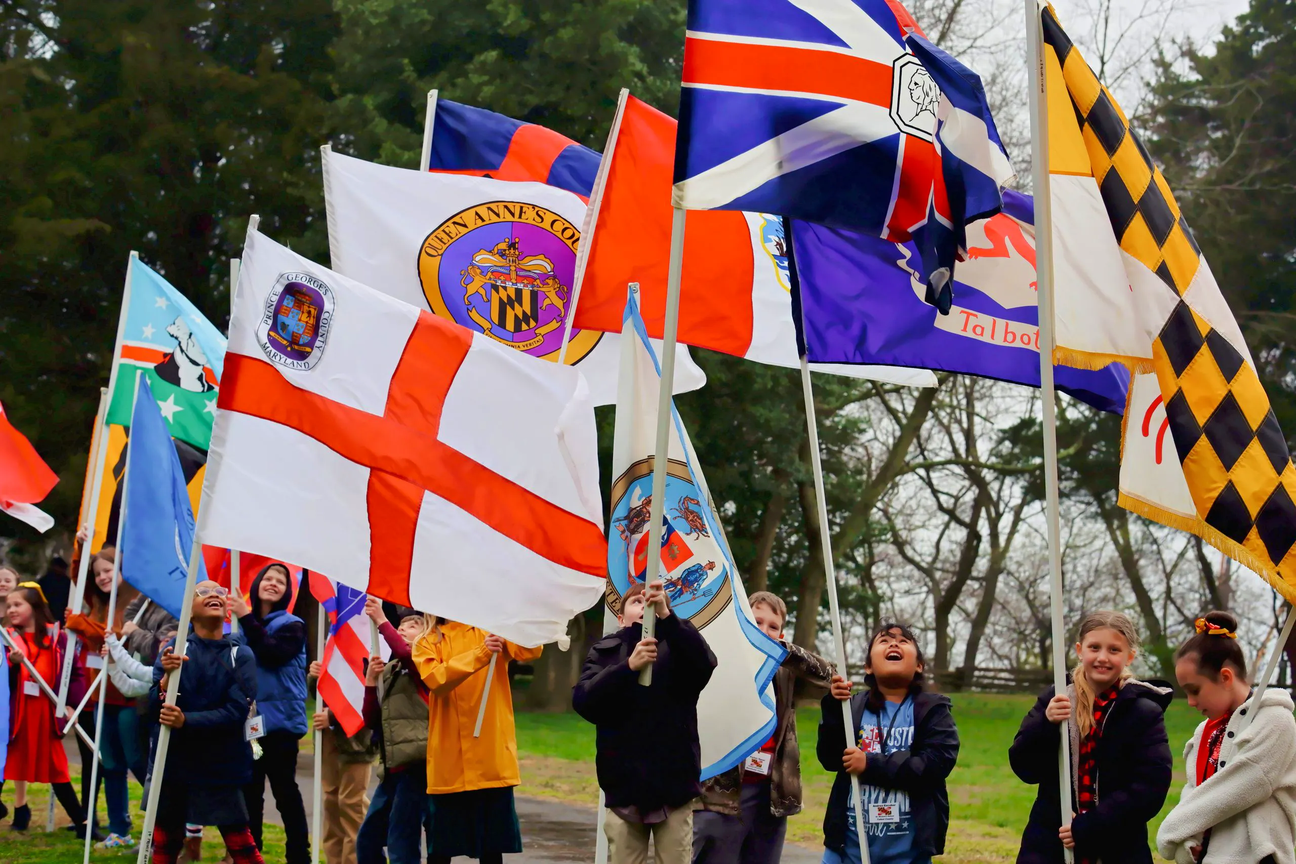 Students lined up holding Maryland county flags